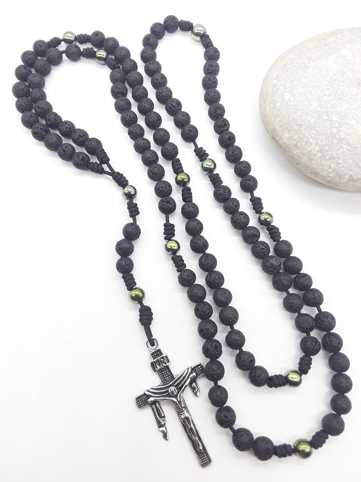 Steadfast Path lava stone and hematite 10-decade Catholic rosary with stainless steel crucifix beside stone by Polmadeva