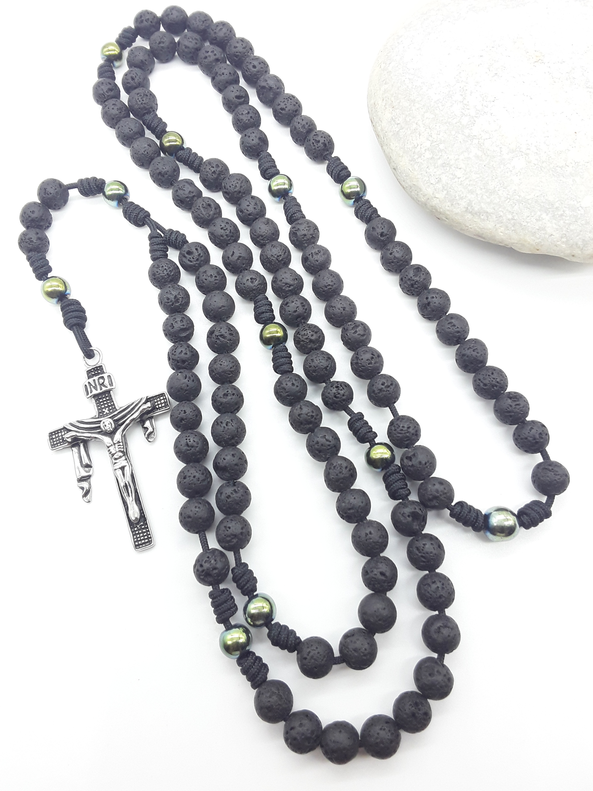 Steadfast Path lava stone and hematite 10-decade Catholic rosary with stainless steel crucifix beside stone by Polmadeva