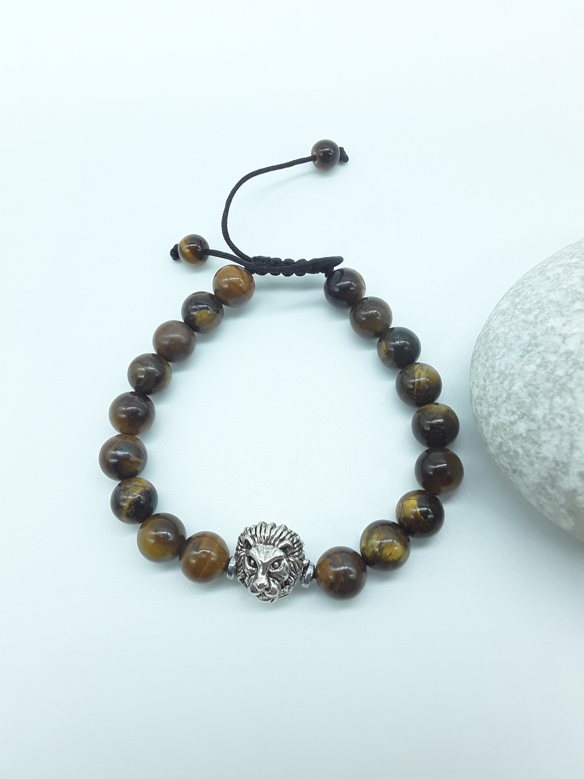 Tiger’s Eye beaded bracelet with metal lion element and adjustable hand-knotted cord on a light background