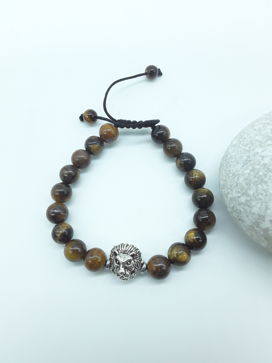 Tiger’s Eye beaded bracelet with metal lion element and adjustable hand-knotted cord on a light background
