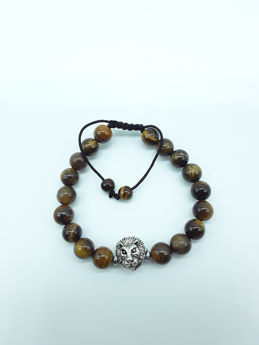 Stillbound bracelet with Tiger’s Eye beads, metal lion element, and adjustable hand-knotted cord on a light background