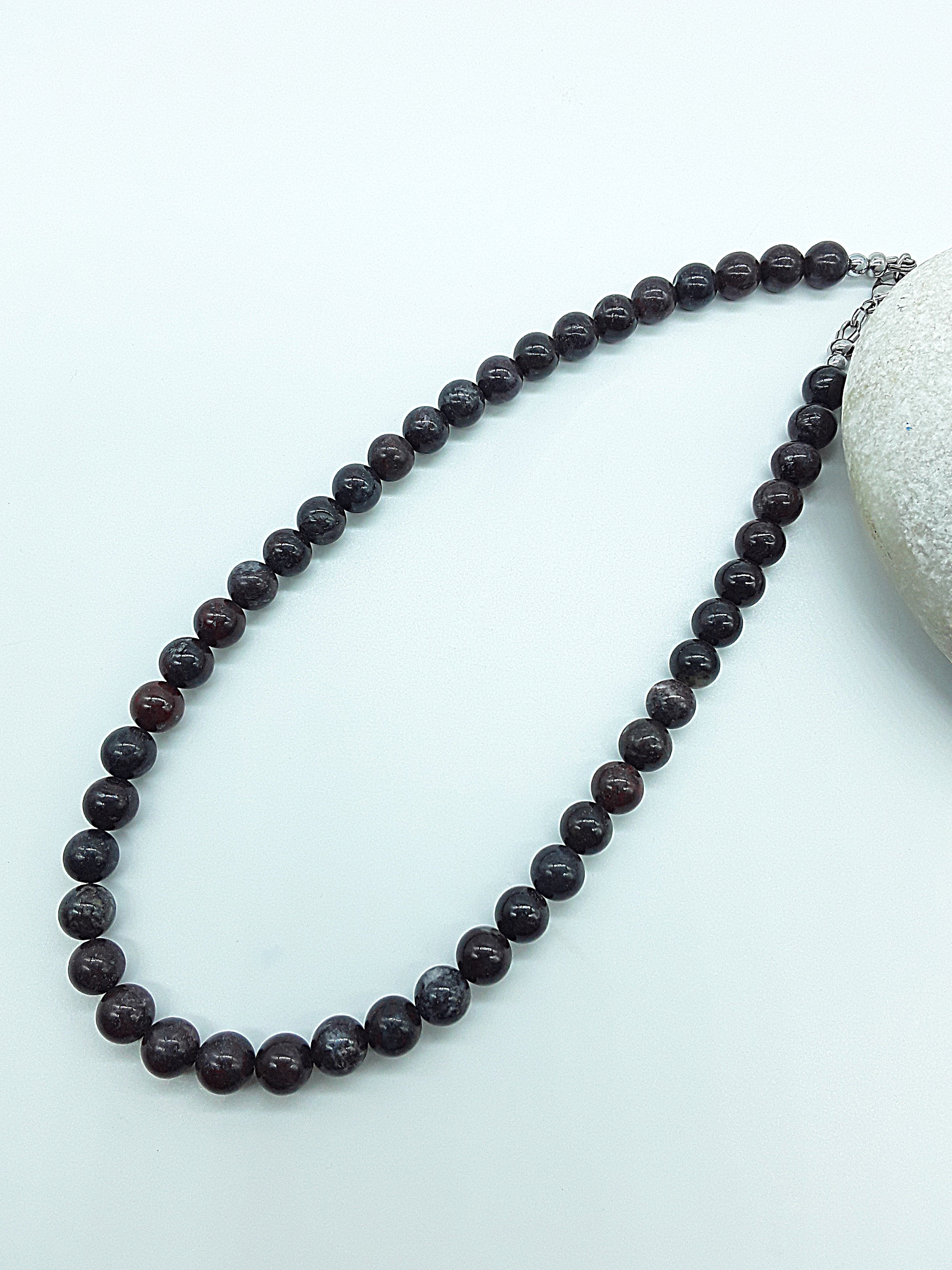 Stone of Resolve Necklace with natural bloodstone beads laid flat, handcrafted gemstone talisman by Polmadeva from the Quiet Power collection