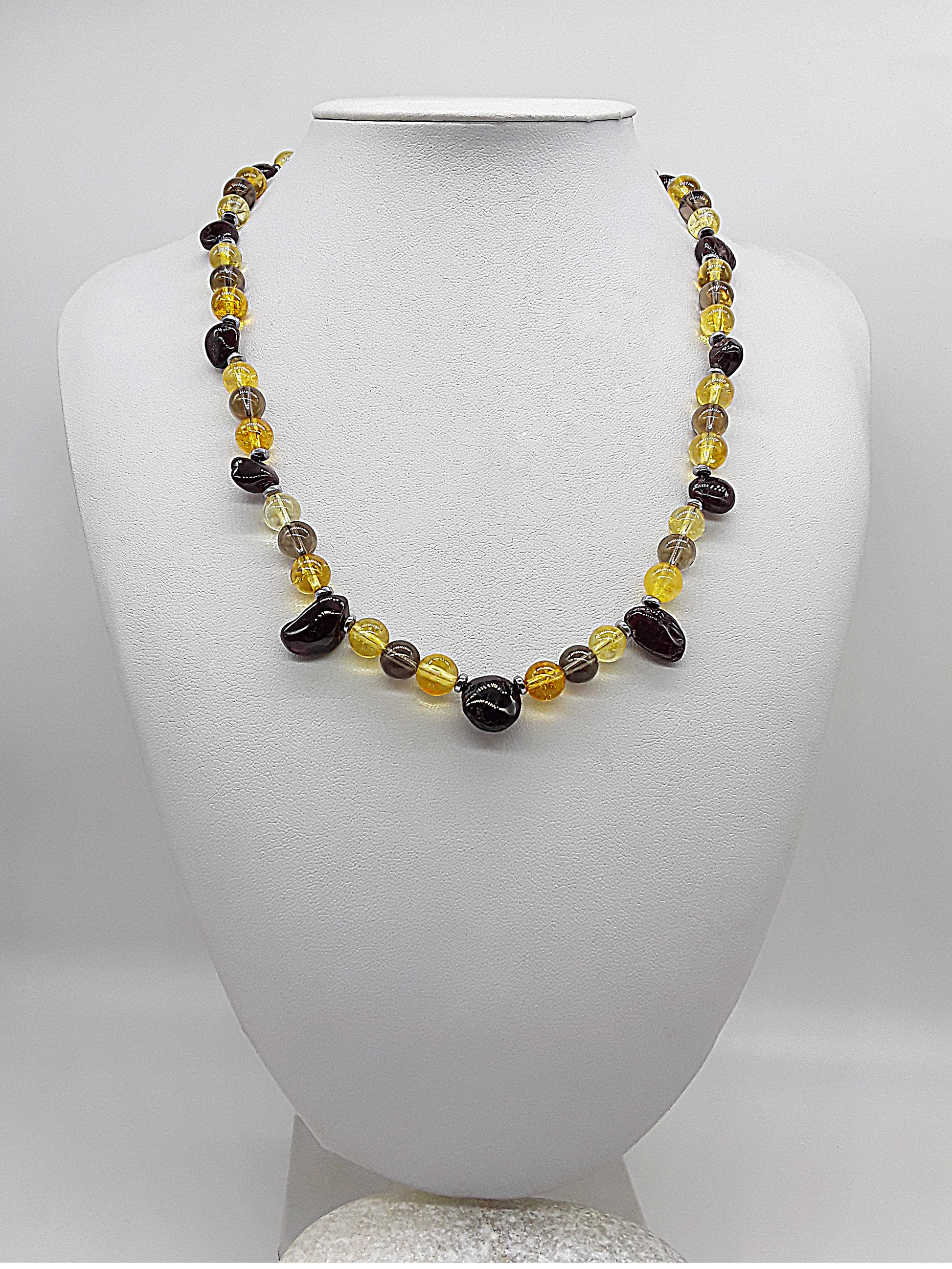 Handmade necklace with citrine, garnet, smoked quartz, and hematite beads displayed on a white mannequin bust.