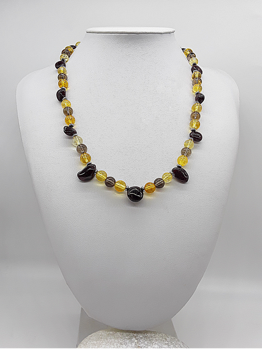 Handmade necklace with citrine, garnet, smoked quartz, and hematite beads displayed on a white mannequin bust.