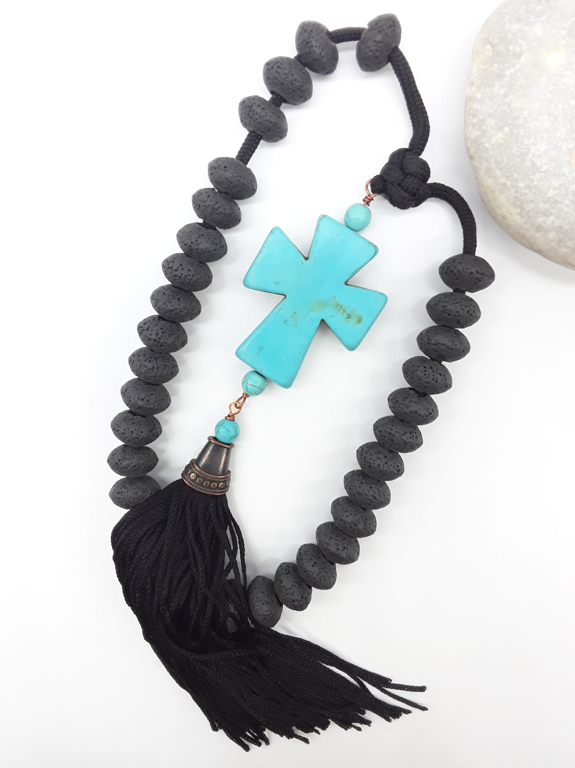 Lava and Howlite Orthodox Paracord Rosary with tassel beside natural stone surface by Polmadeva.
