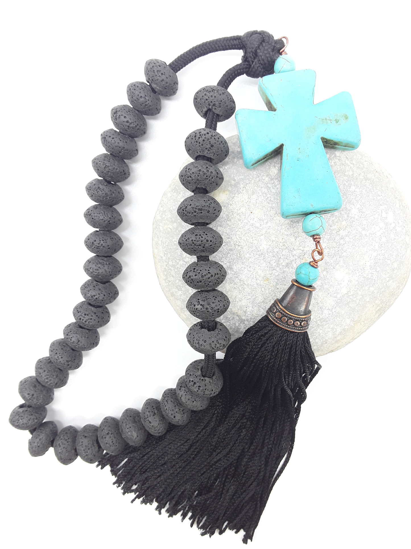Lava and Howlite Orthodox Paracord Rosary resting on natural stone surface with tassel and cross by Polmadeva.