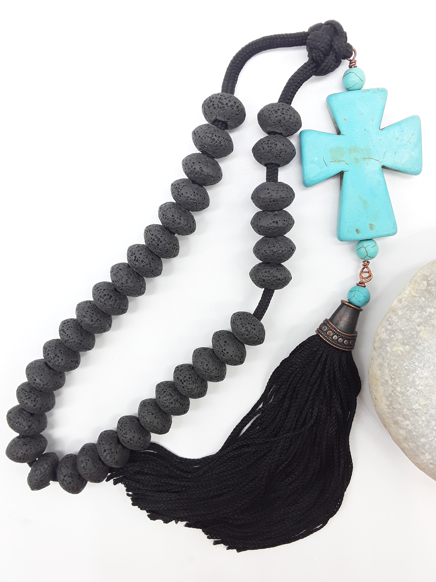 Lava and Howlite Orthodox Paracord Rosary with tassel beside natural stone surface by Polmadeva.