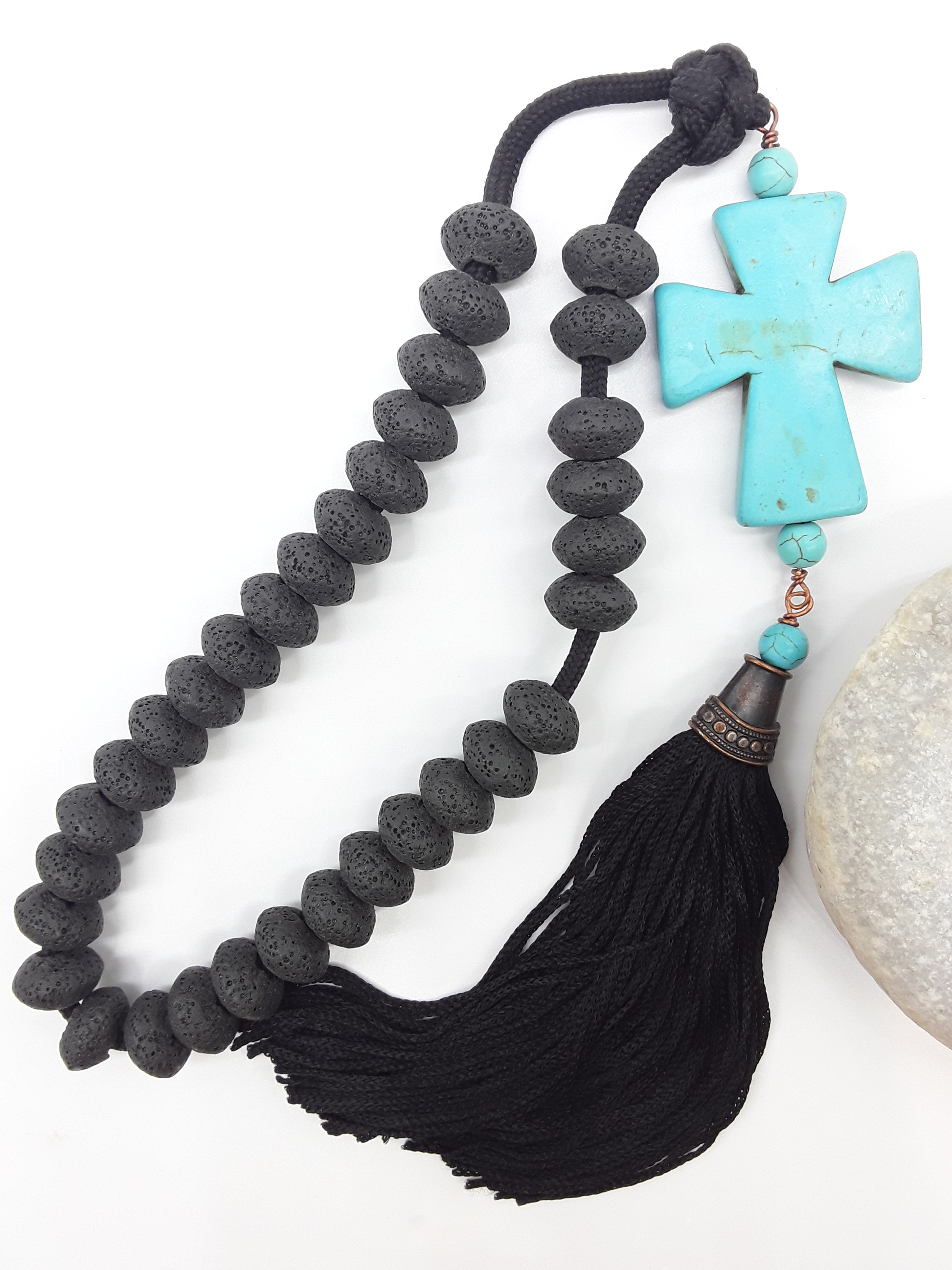 Lava and Howlite Orthodox Paracord Rosary with tassel beside natural stone surface by Polmadeva.