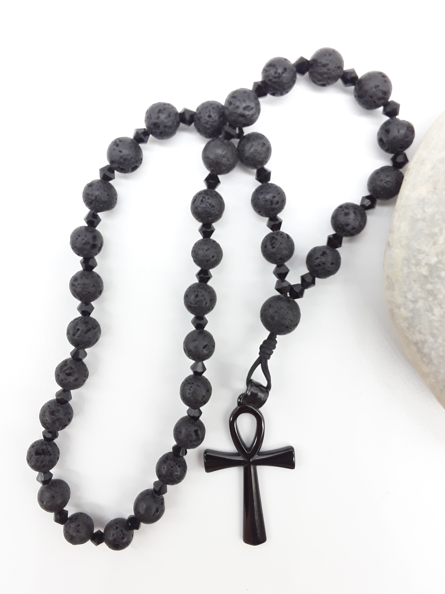 Lava and black crystal Orthodox Rosary with Ankh cross beside natural stone surface by Polmadeva.