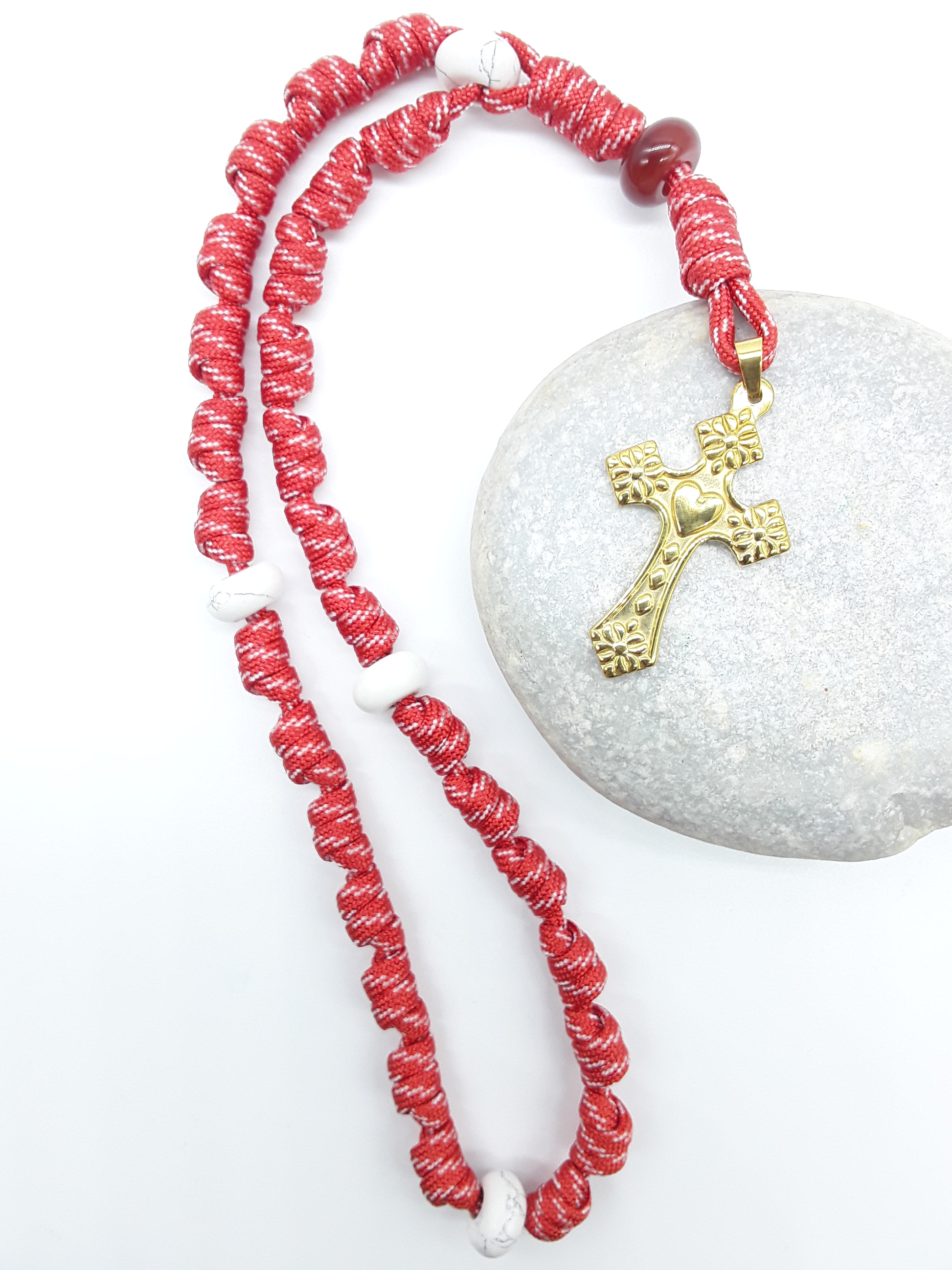 Knotted Anglican Rosary with Carnelian and Howlite elements and Golden Heart Cross arranged on white stone, Polmadeva