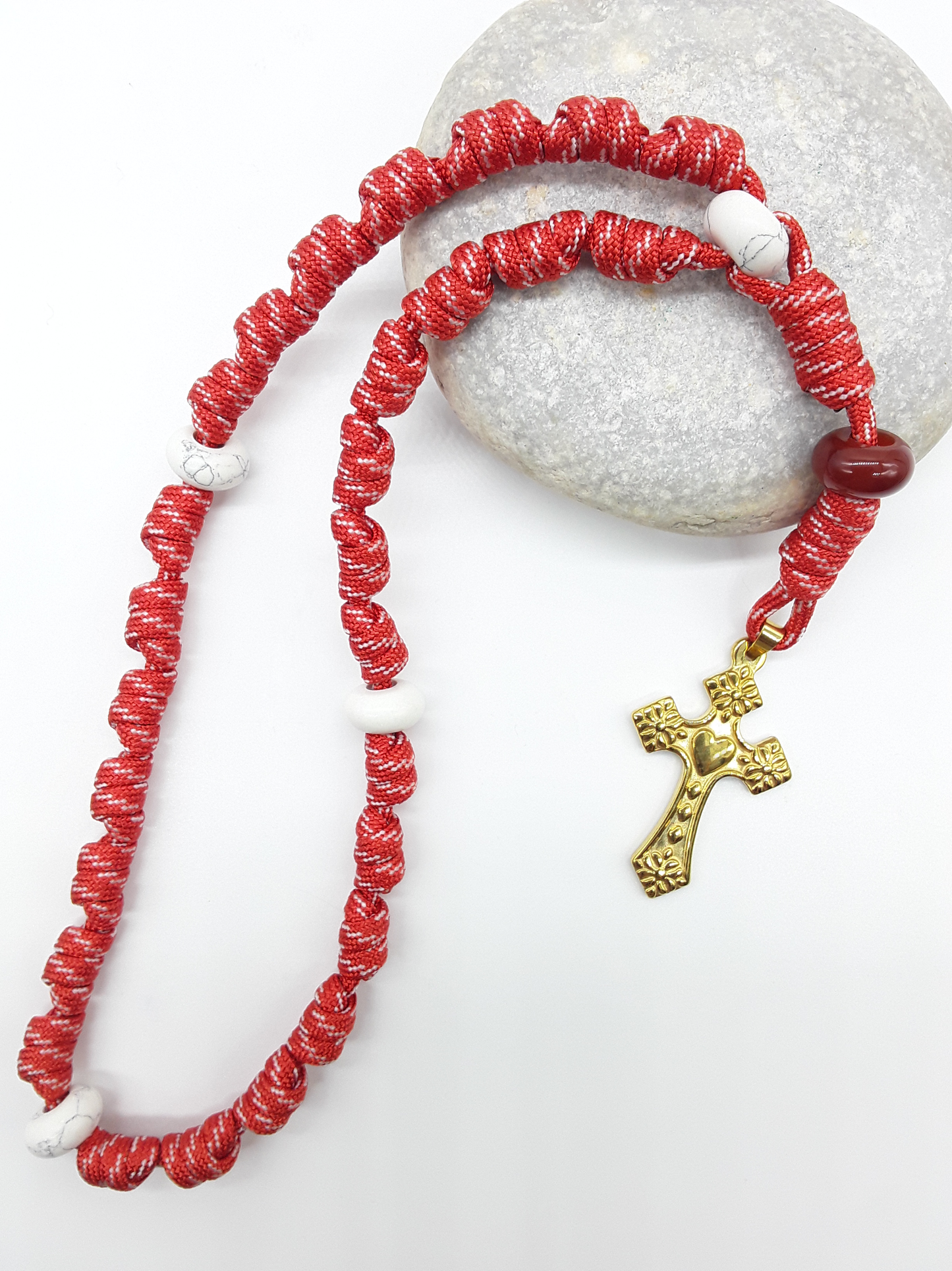 Knotted Anglican Rosary with Carnelian and Howlite elements and Golden Heart Cross arranged on white stone, Polmadeva
