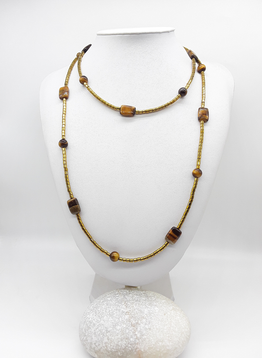 Long gold-toned beaded necklace with Tiger’s Eye and hematite beads displayed on a white mannequin bust.