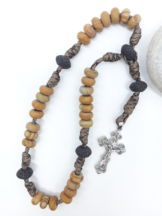 The Grounded Path — Natural Wood and Lava Stone Paracord Anglican Prayer Beads with stainless steel Cross by Polmadeva beside natural stone.