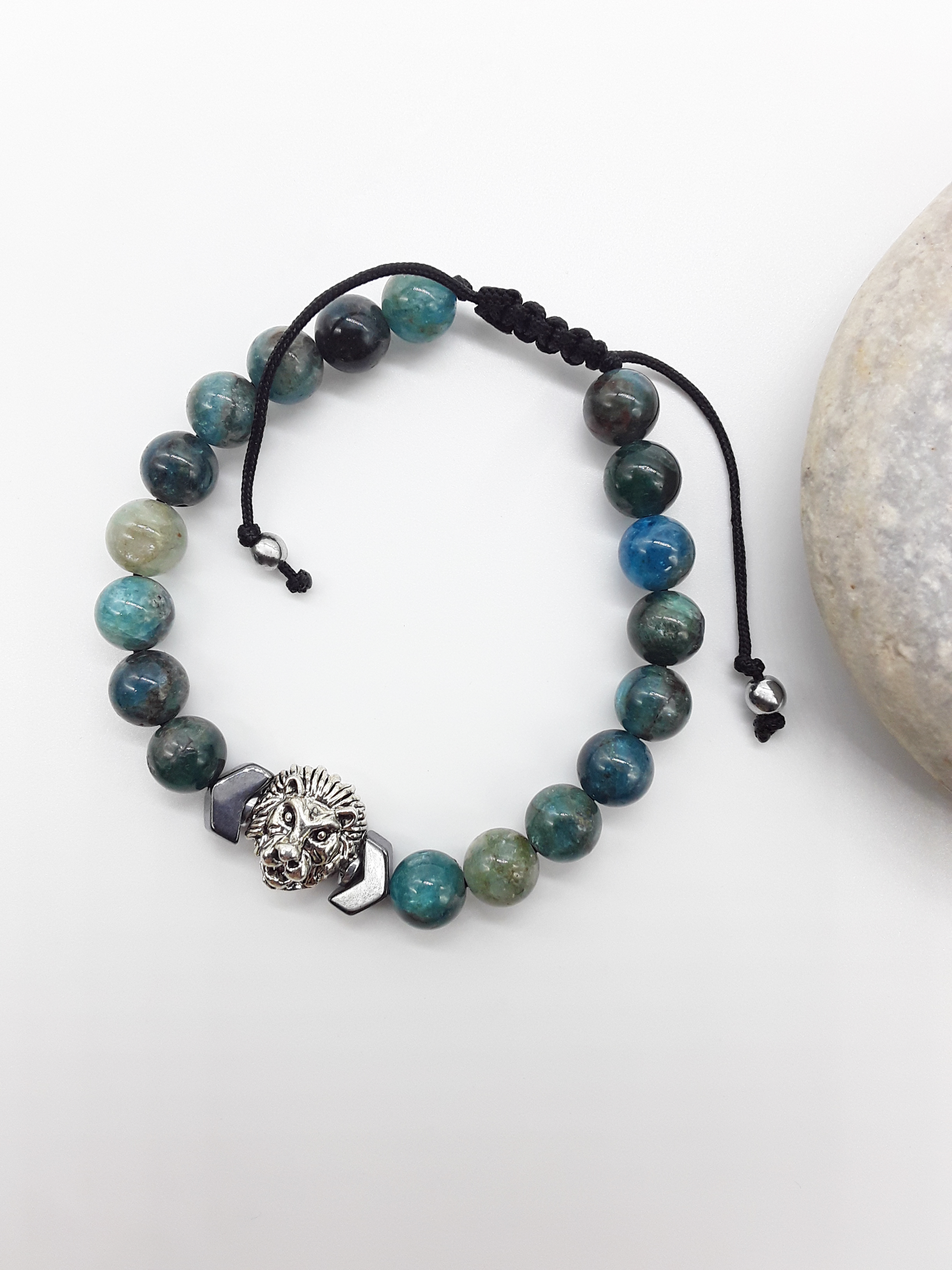 Polmadeva Lion Bracelet The Inner Course photographed beside stone, highlighting apatite stones, hematite arrow, and grounded design