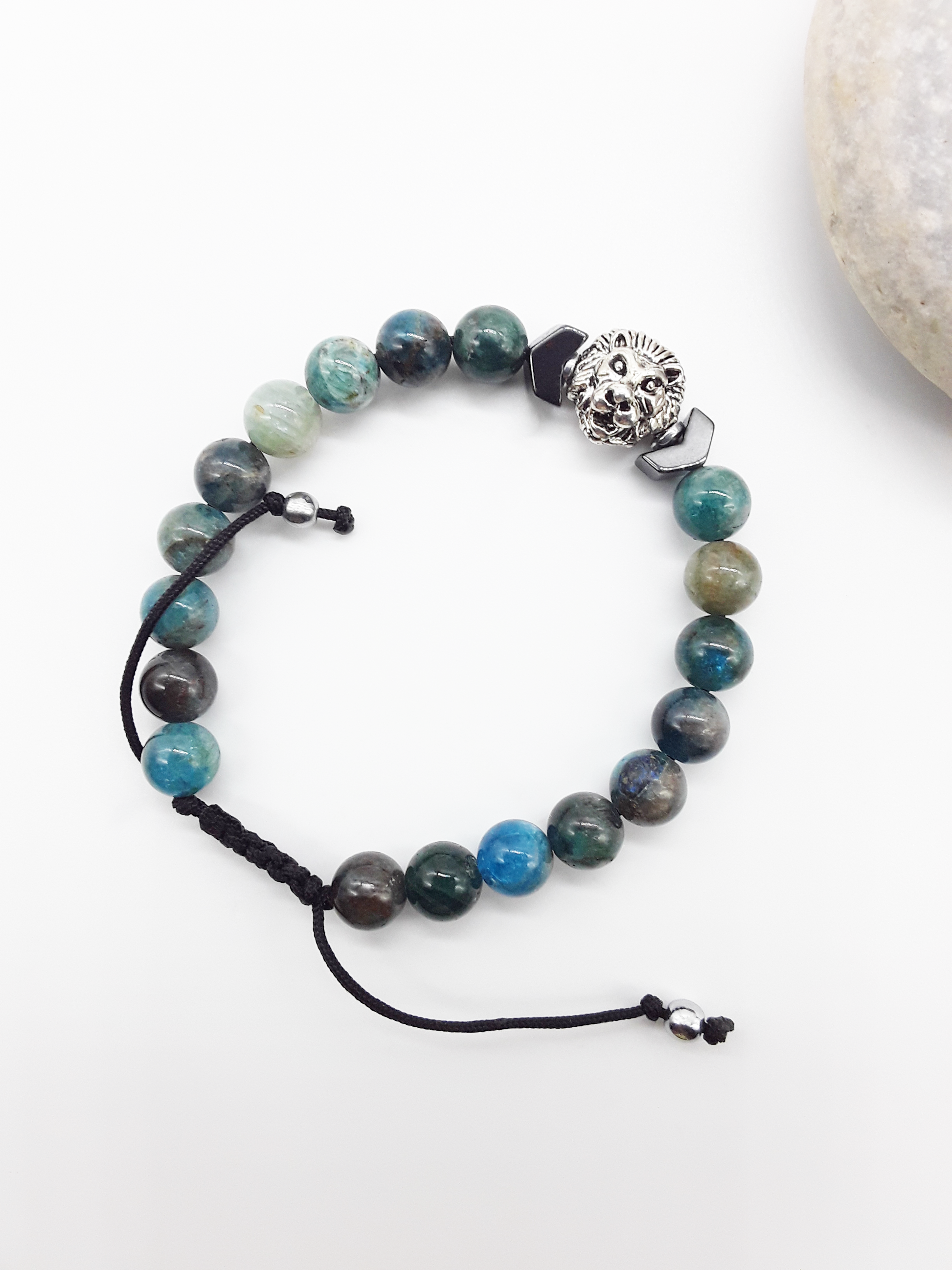 Polmadeva Lion Bracelet The Inner Course photographed beside stone, highlighting apatite stones, hematite arrow, and grounded design