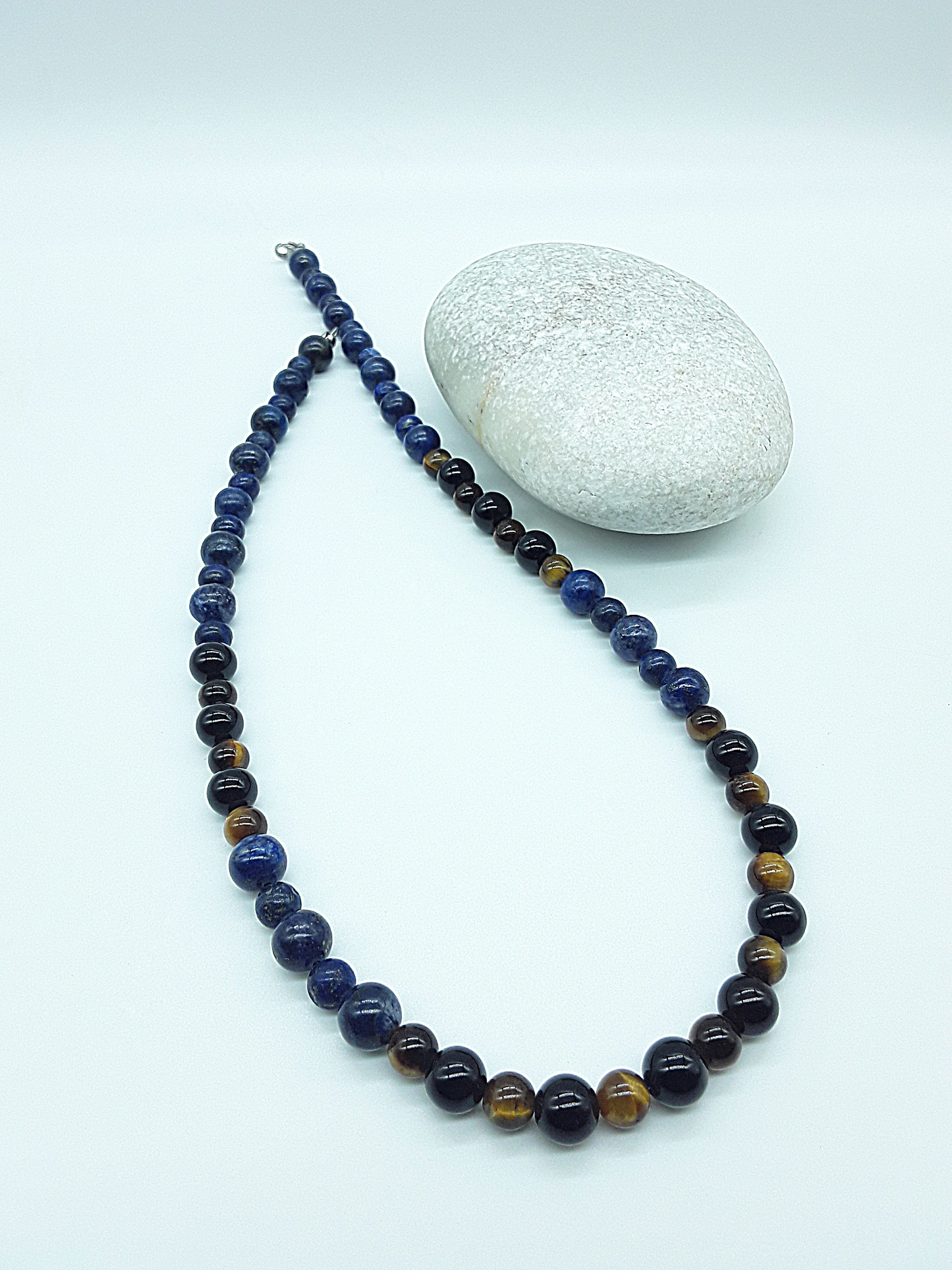 Polmadeva Inner Sight Necklace with lapis lazuli, tiger’s eye and black onyx beads arranged diagonally beside natural stone, Soul Vision collection