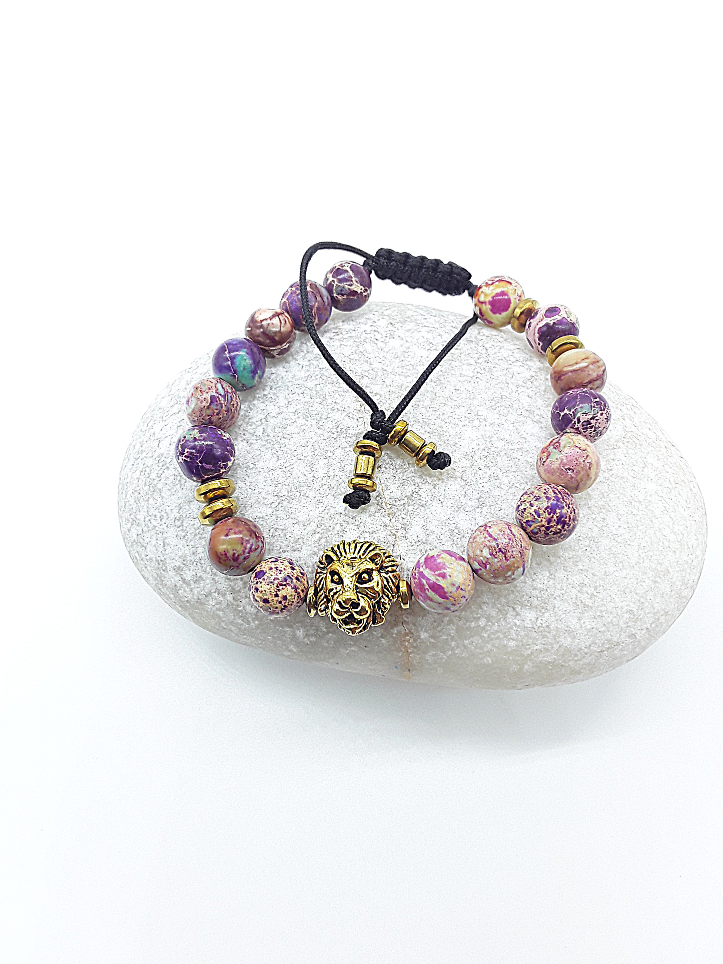 Lion bracelet with imperial jasper beads resting on a natural stone