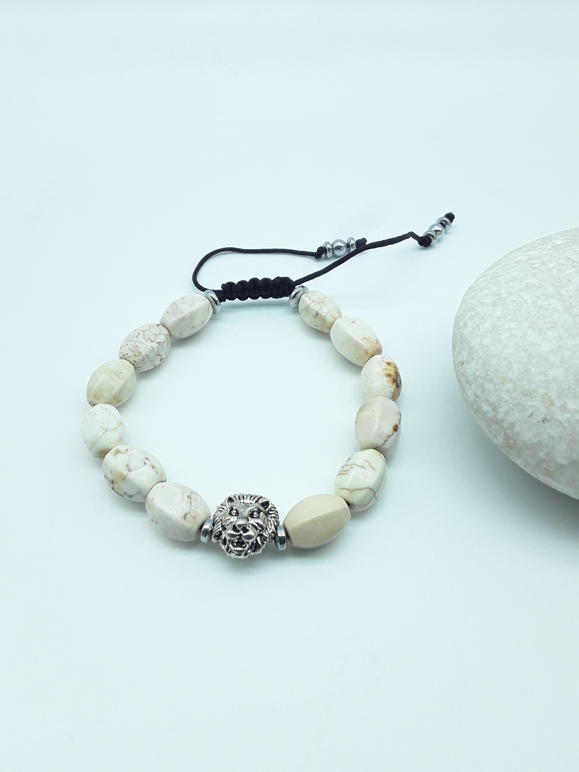 Ivory Turquoise lion bracelet beside natural stone, highlighting grounded elegance and protective presence