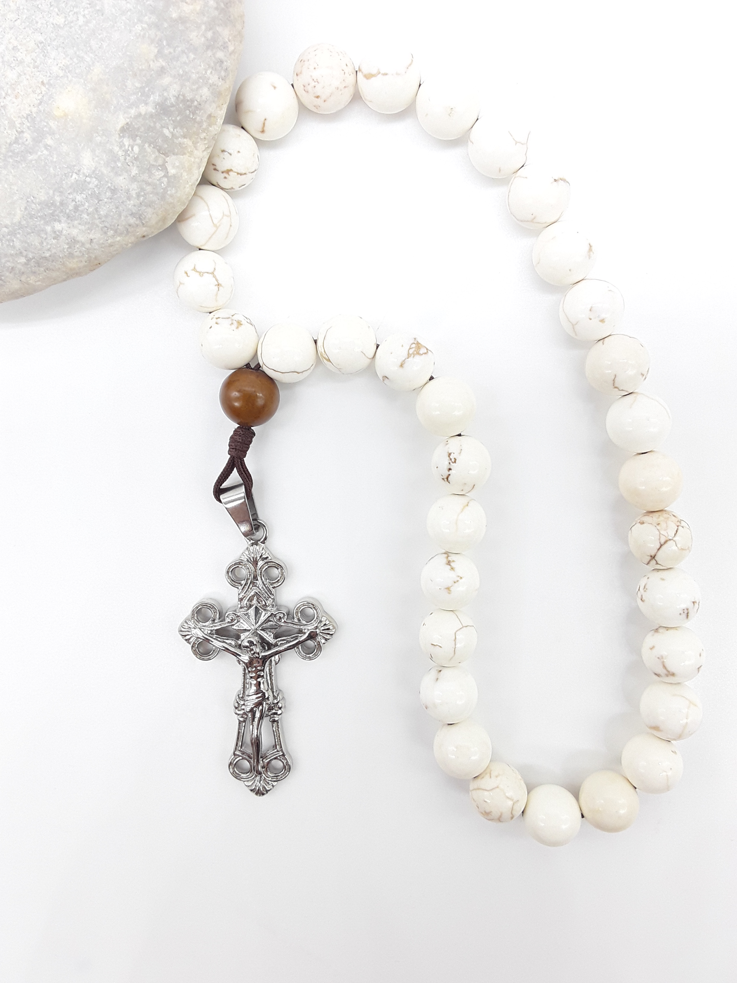 Magnesite Paracord Orthodox Rosary with silver crucifix beside natural stone surface by Polmadeva.