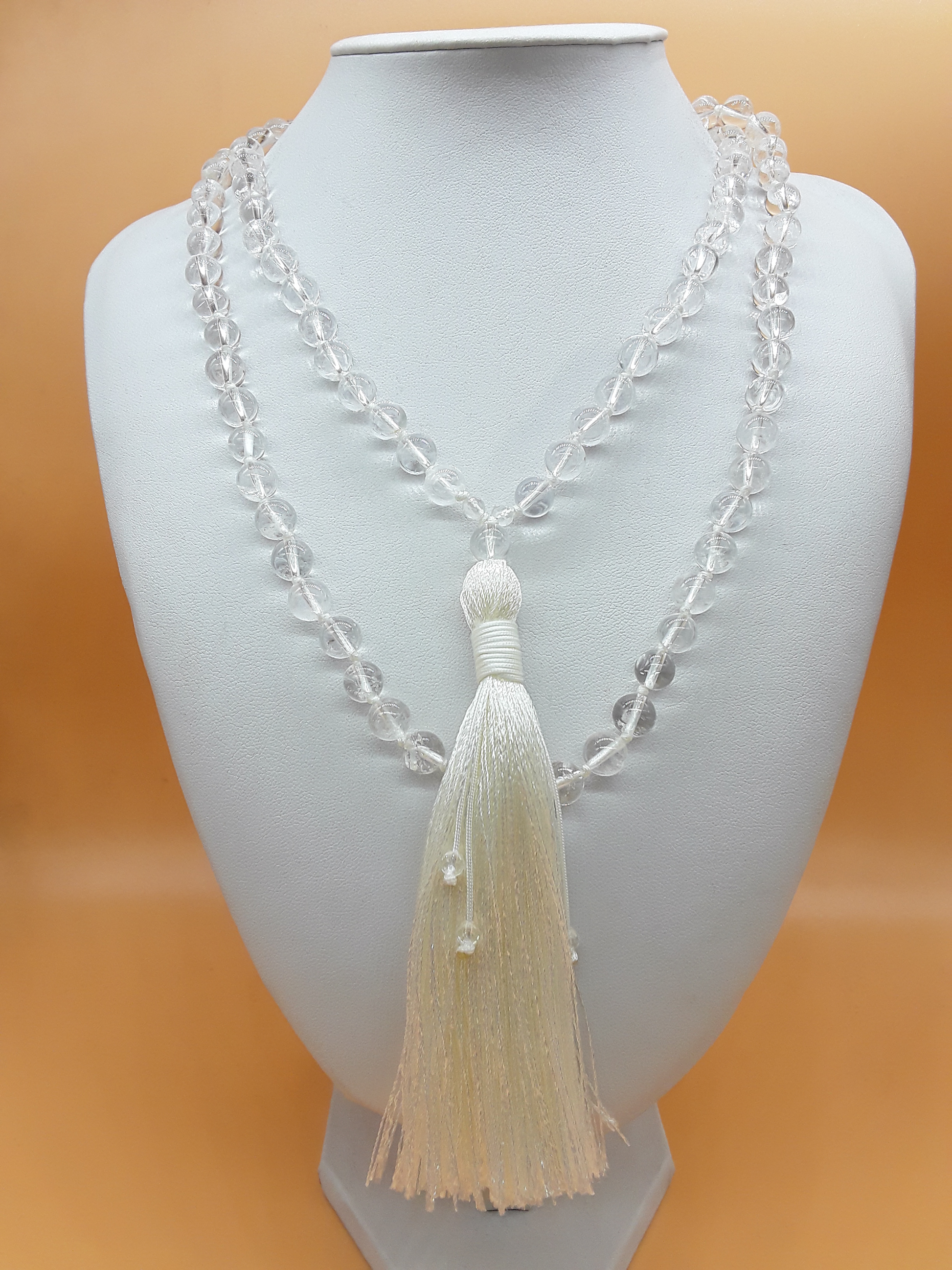 Crystal Quartz Mala Beads with white tassel displayed on white mannequin, Polmadeva