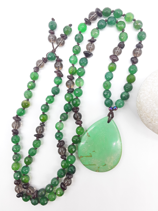 Agate and Smoky Quartz Mala Beads with teardrop Agate pendant placed beside white stone on white background, Polmadeva