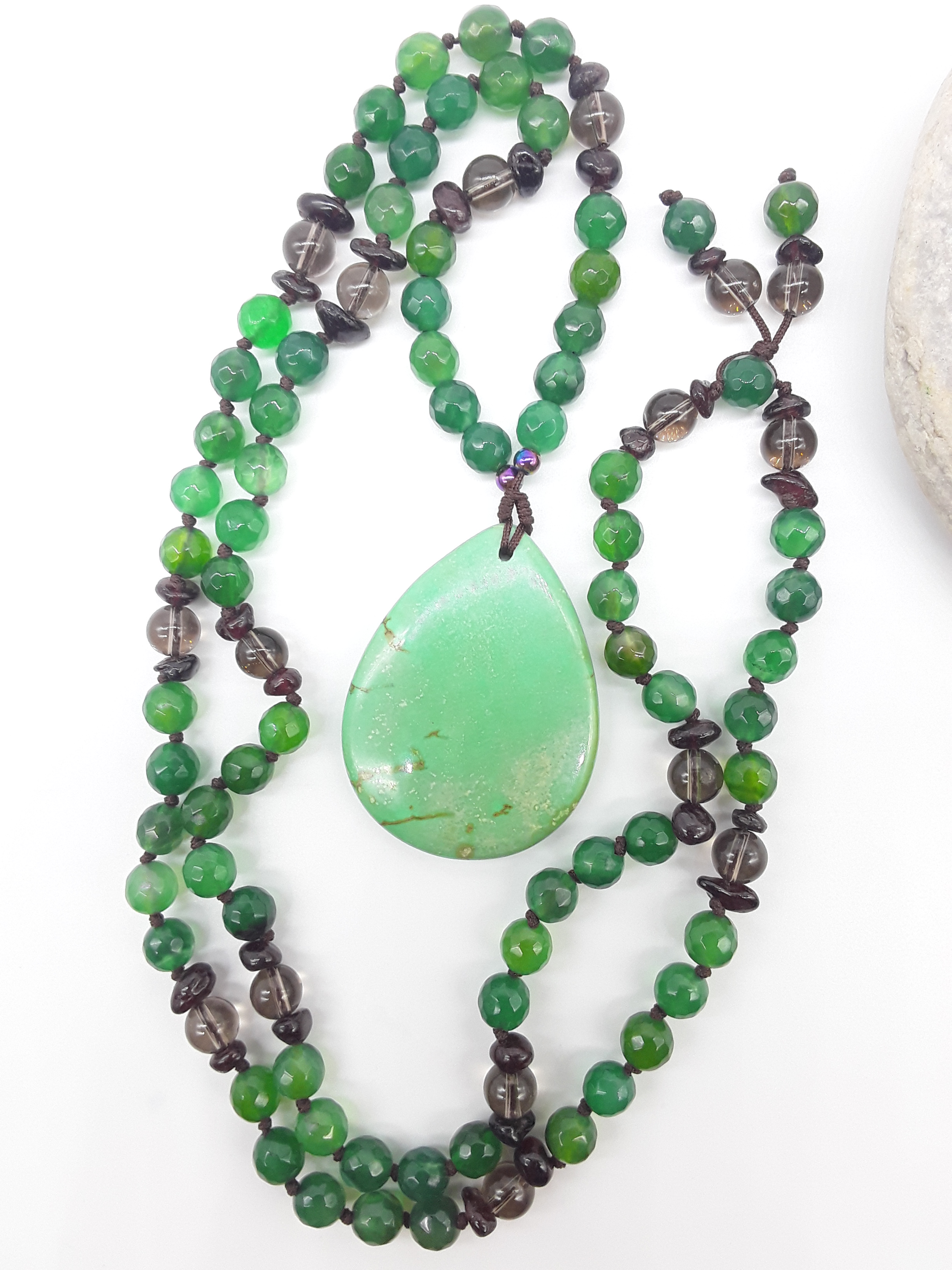 Agate and Smoky Quartz Mala Beads with teardrop Agate pendant placed beside white stone on white background, Polmadeva