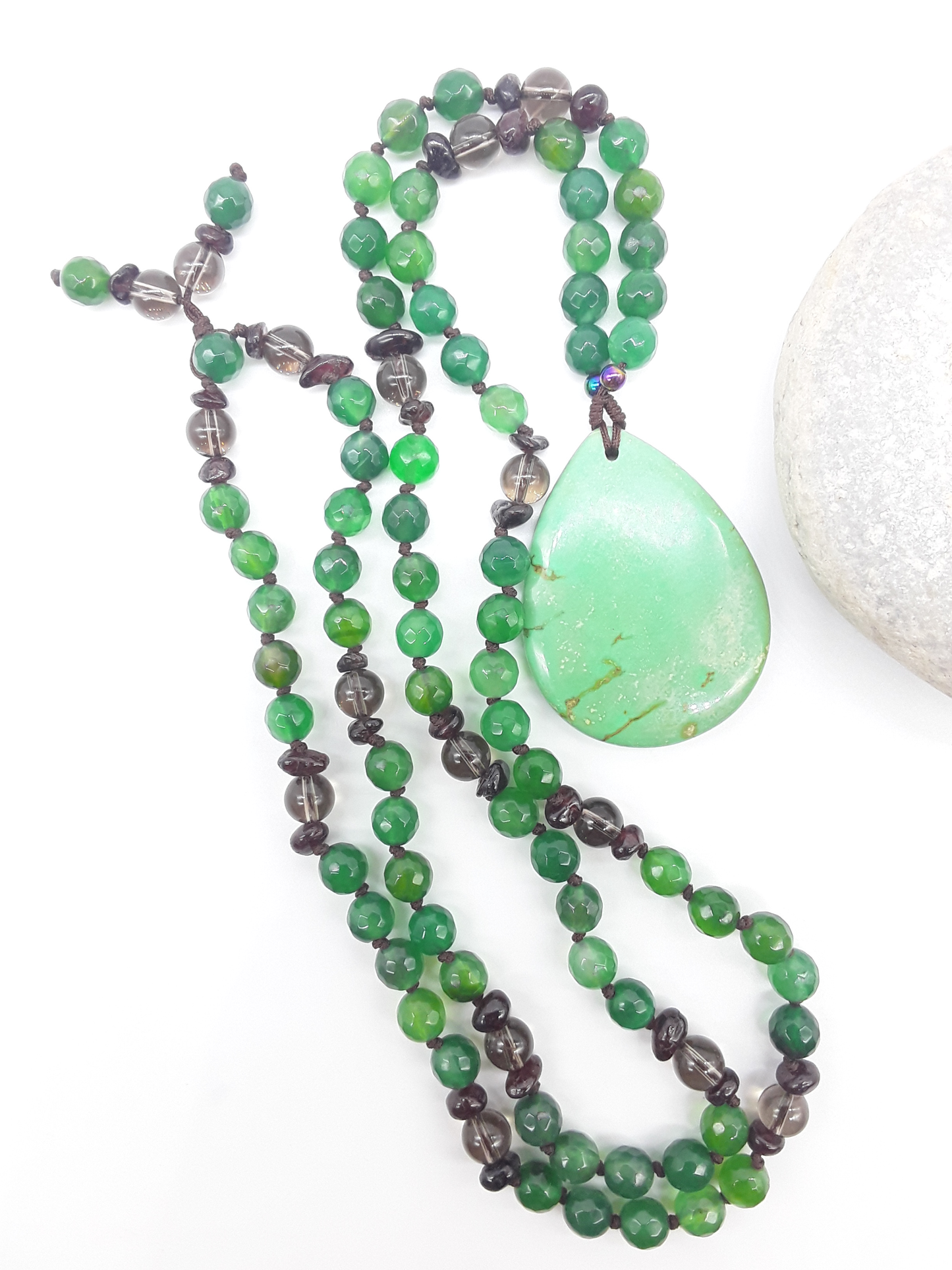 Agate and Smoky Quartz Mala Beads with teardrop Agate pendant placed beside white stone on white background, Polmadeva