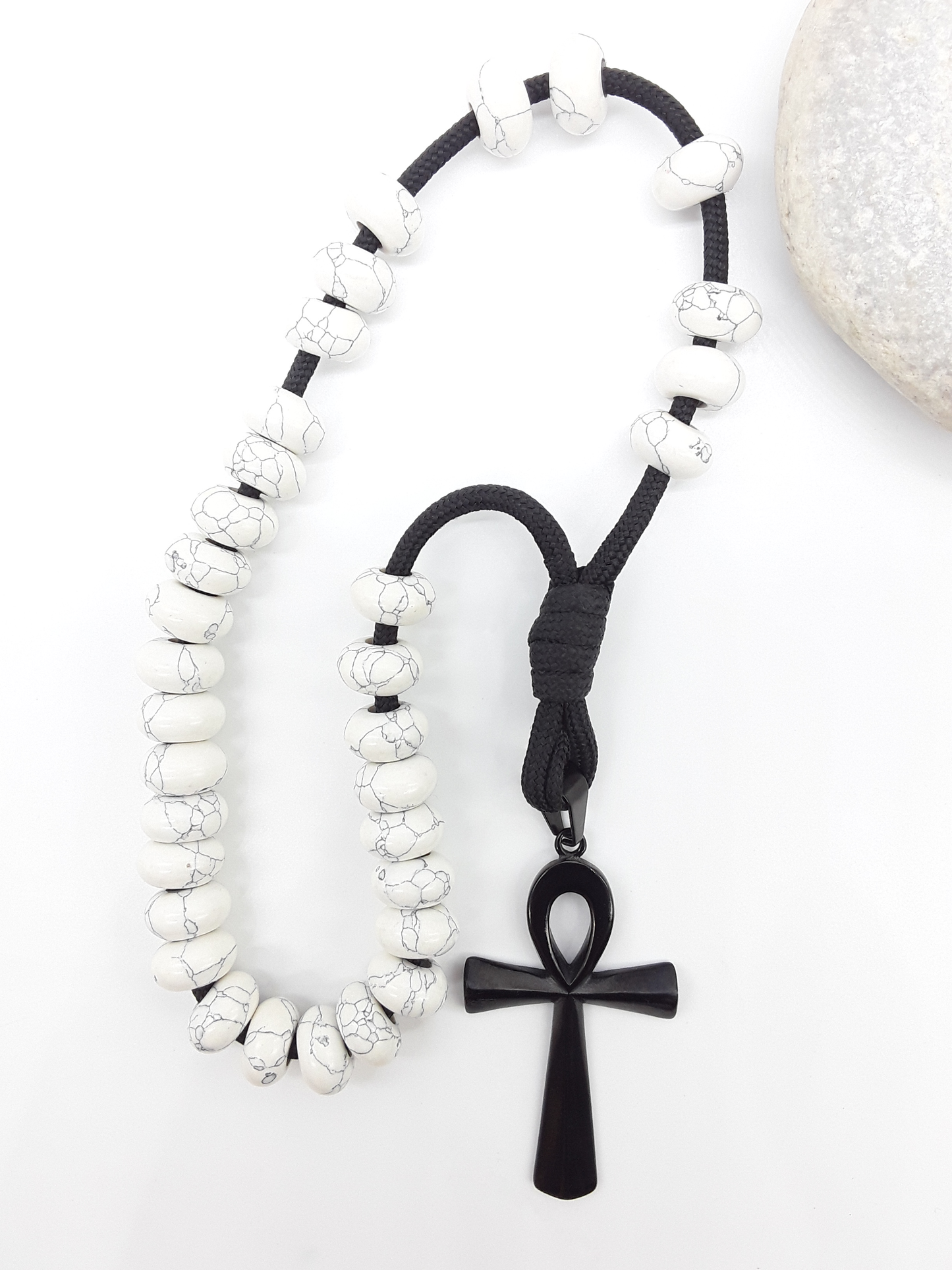 Howlite Paracord Orthodox Rosary with black Ankh cross beside natural stone surface by Polmadeva.