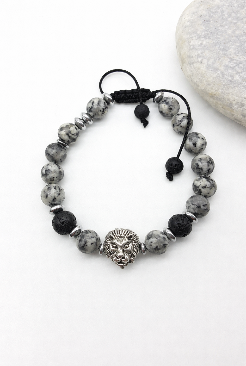Jasper and lava lion bracelet beside natural stone, highlighting balance, endurance, and quiet strength
