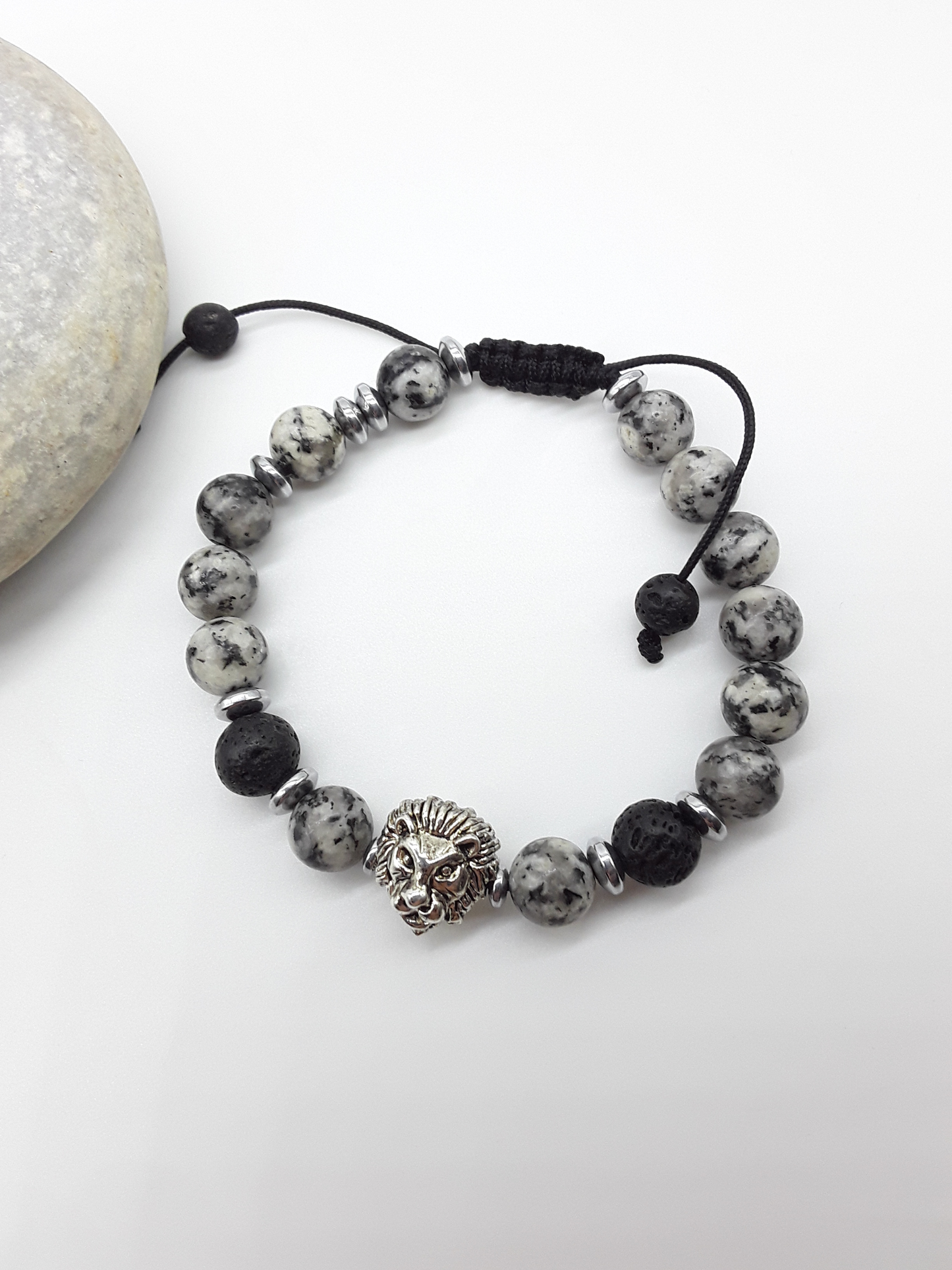 Jasper and lava lion bracelet beside natural stone, highlighting balance, endurance, and quiet strength