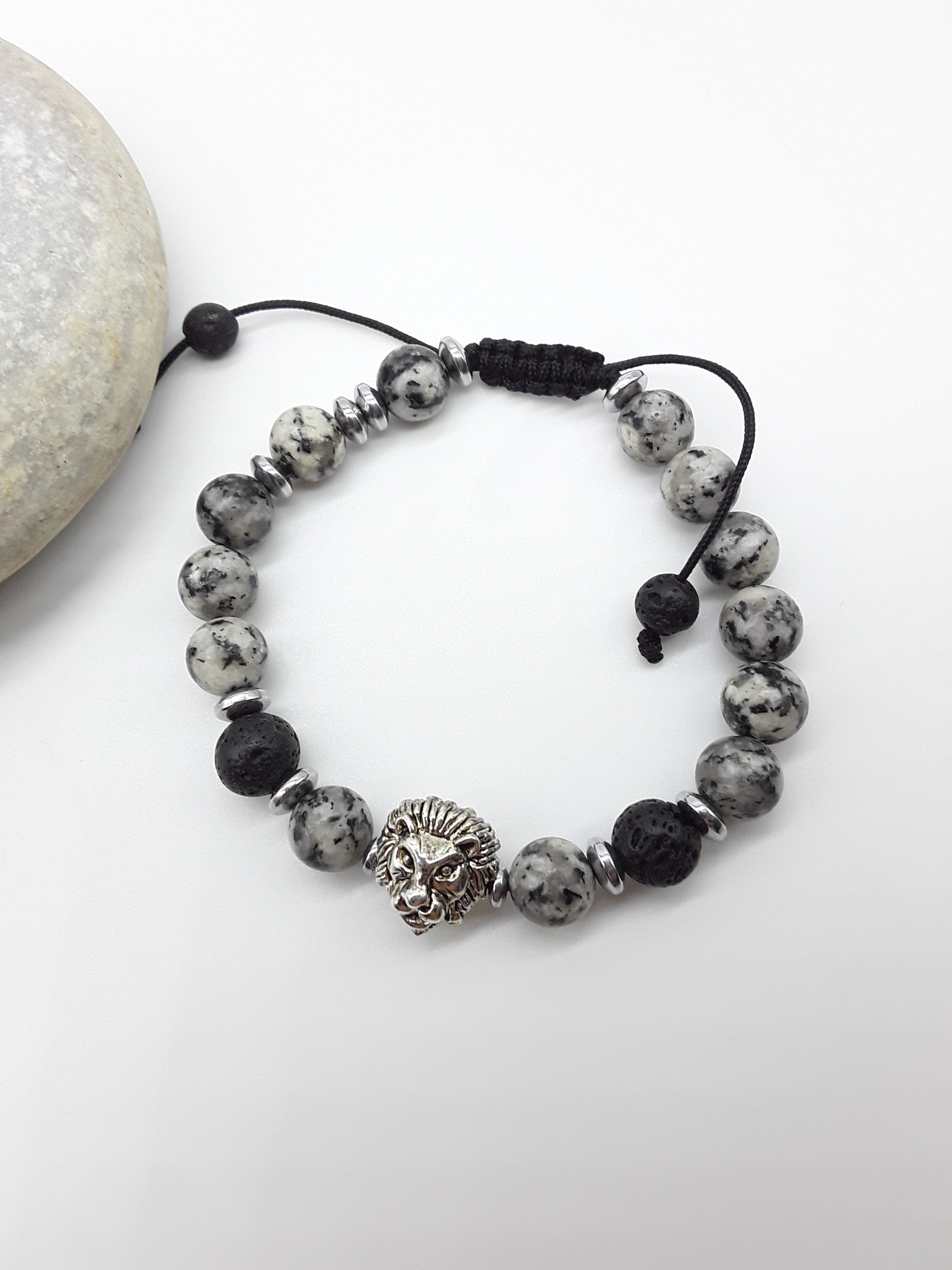 Jasper and lava lion bracelet beside natural stone, highlighting balance, endurance, and quiet strength