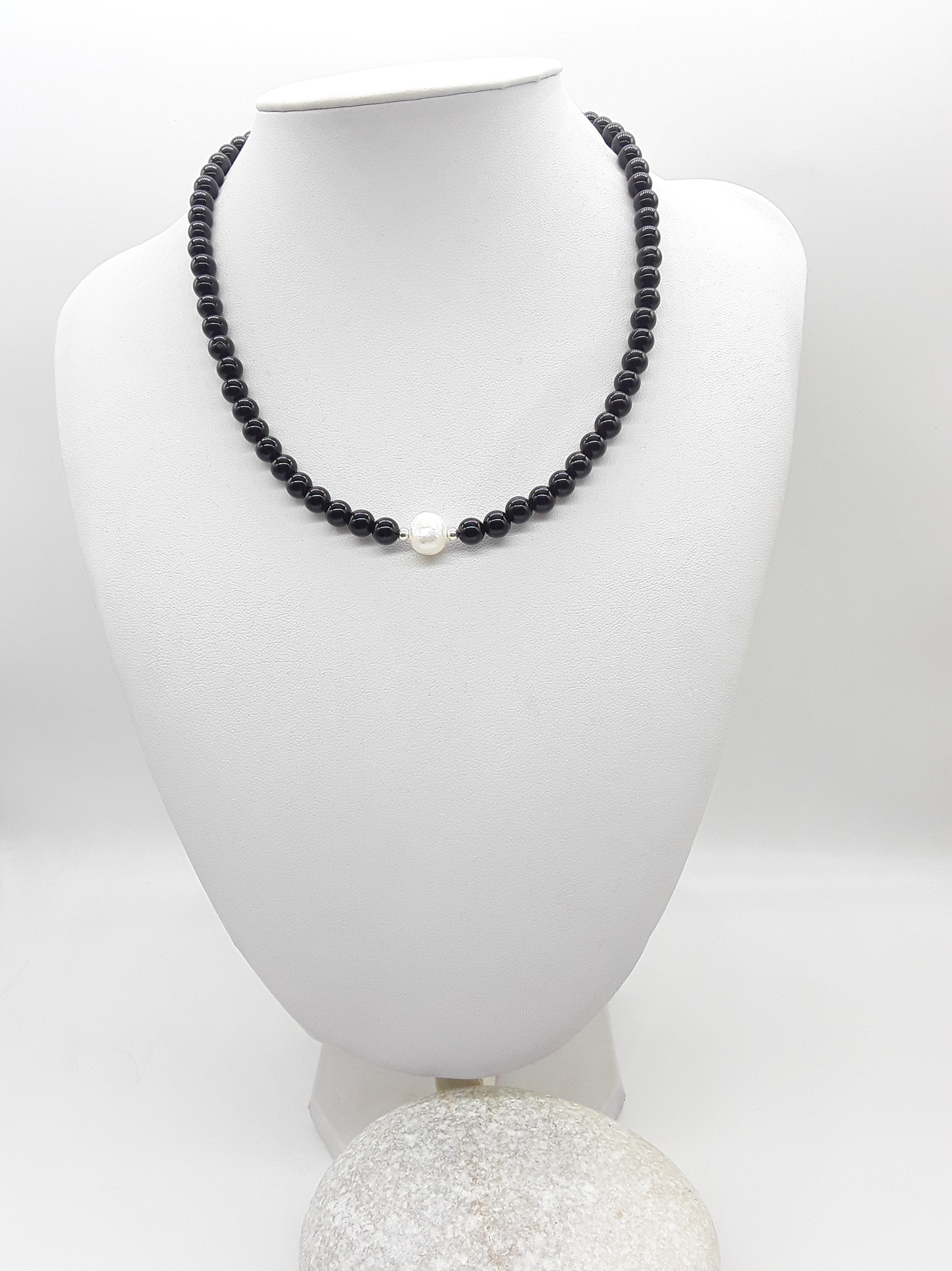 Still Core Necklace by Polmadeva with black onyx beads and central pearl displayed on jewelry bust