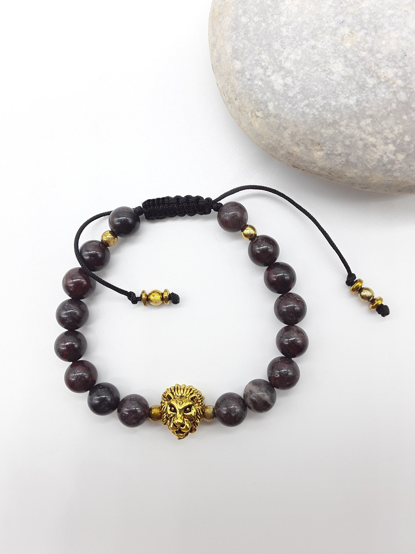 Bloodstone beaded lion bracelet placed beside natural stone elements