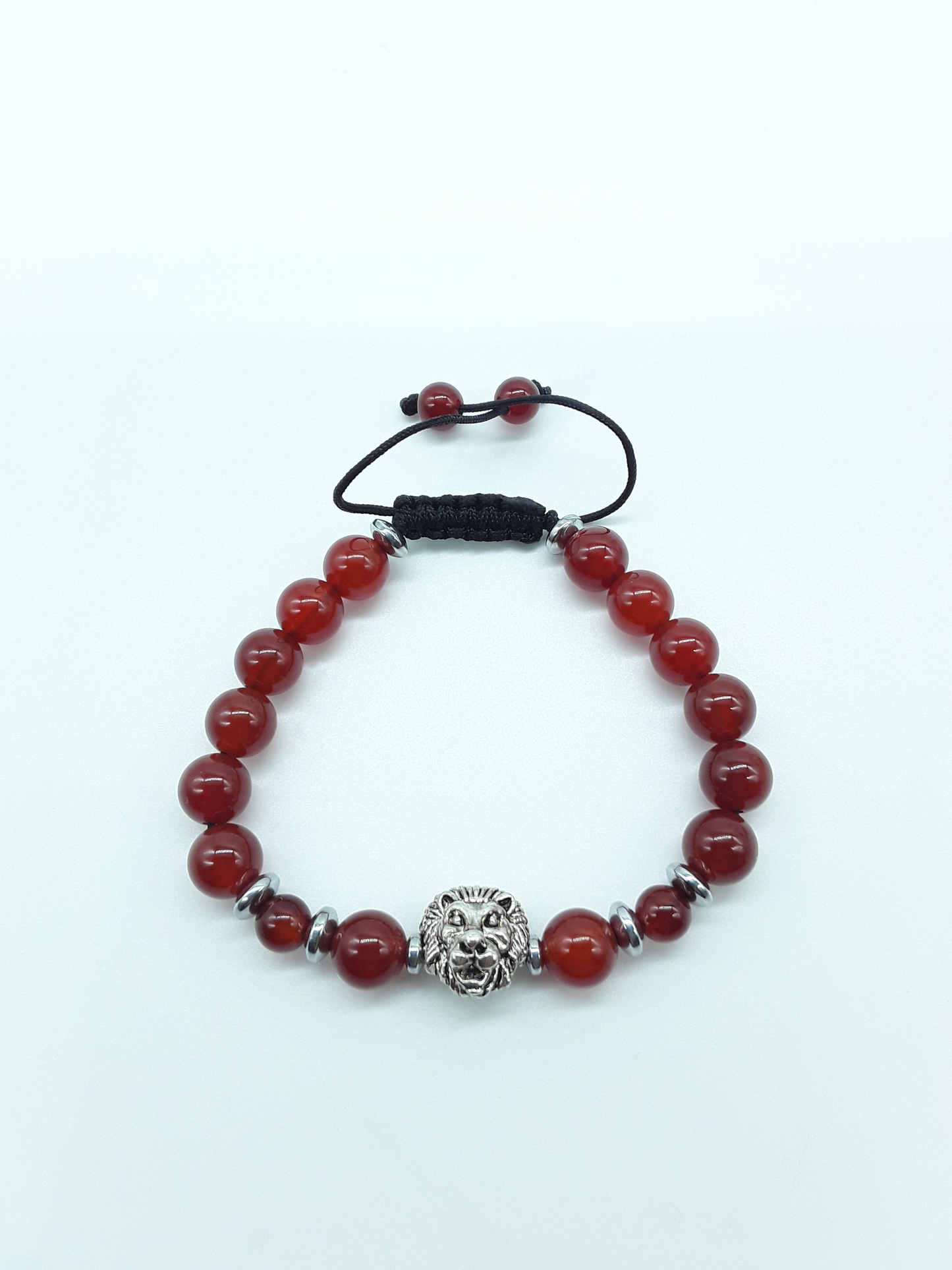 Unmoved Flame bracelet with Carnelian beads and metal lion centerpiece on a light neutral background
