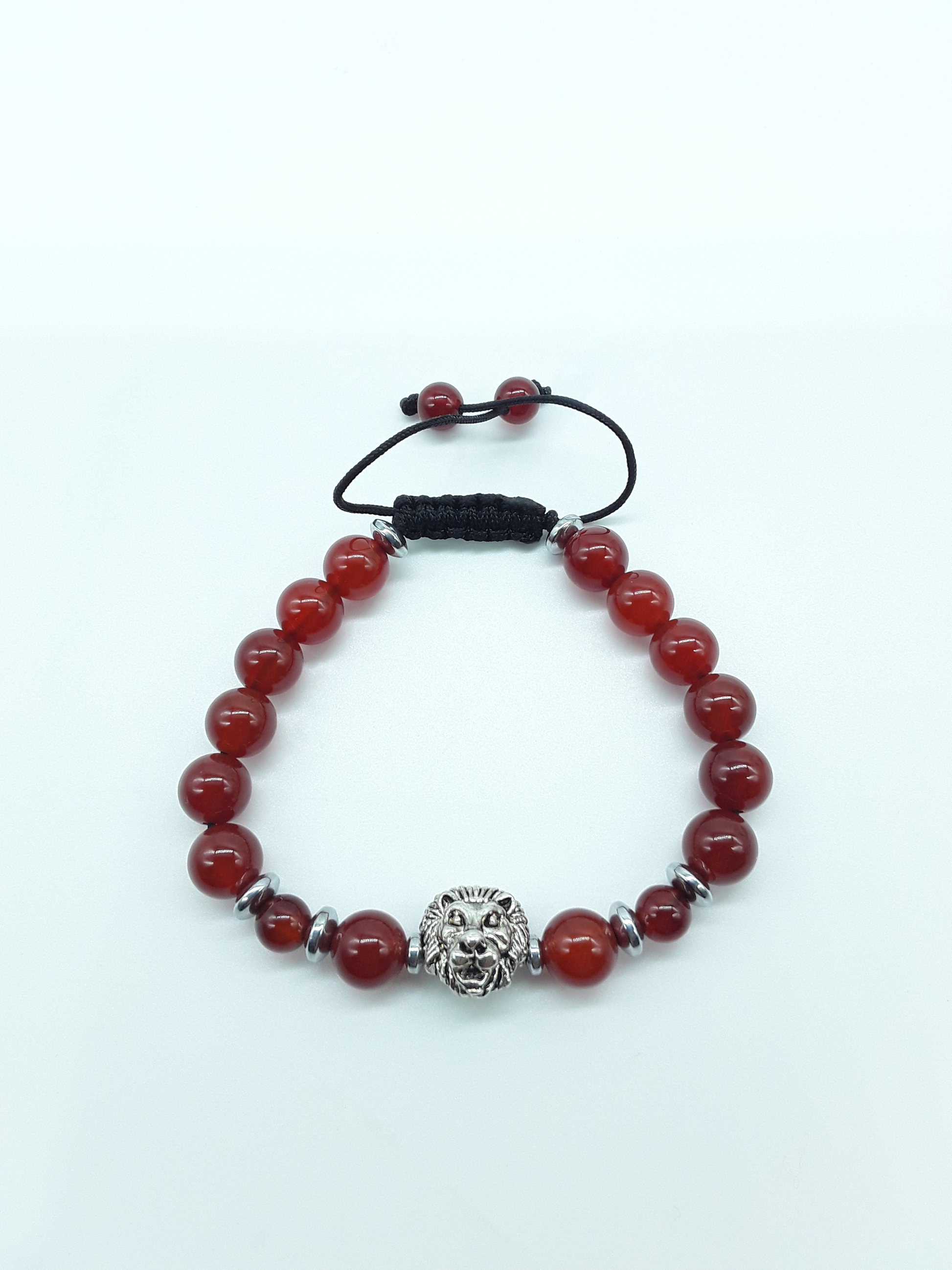 Unmoved Flame bracelet with Carnelian beads and metal lion centerpiece on a light neutral background