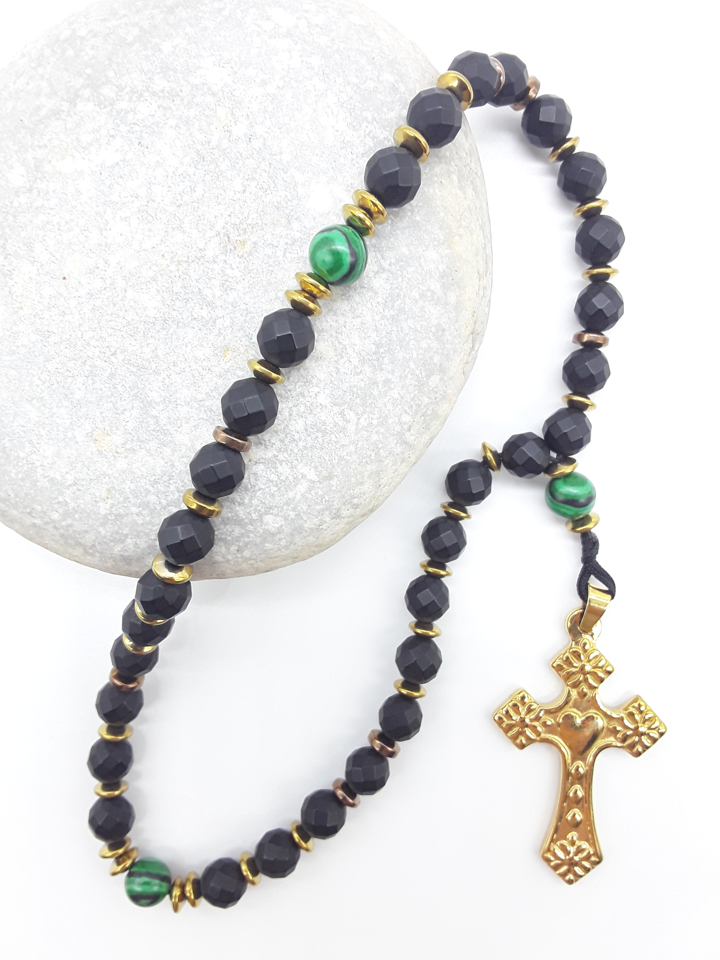 The Verdant Vigil — Black Onyx & Malachite Orthodox Rosary by Polmadeva, faceted black onyx beads with malachite accents and stainless steel cross resting on natural stone, highlighting rhythm, structure, and attentive prayer.