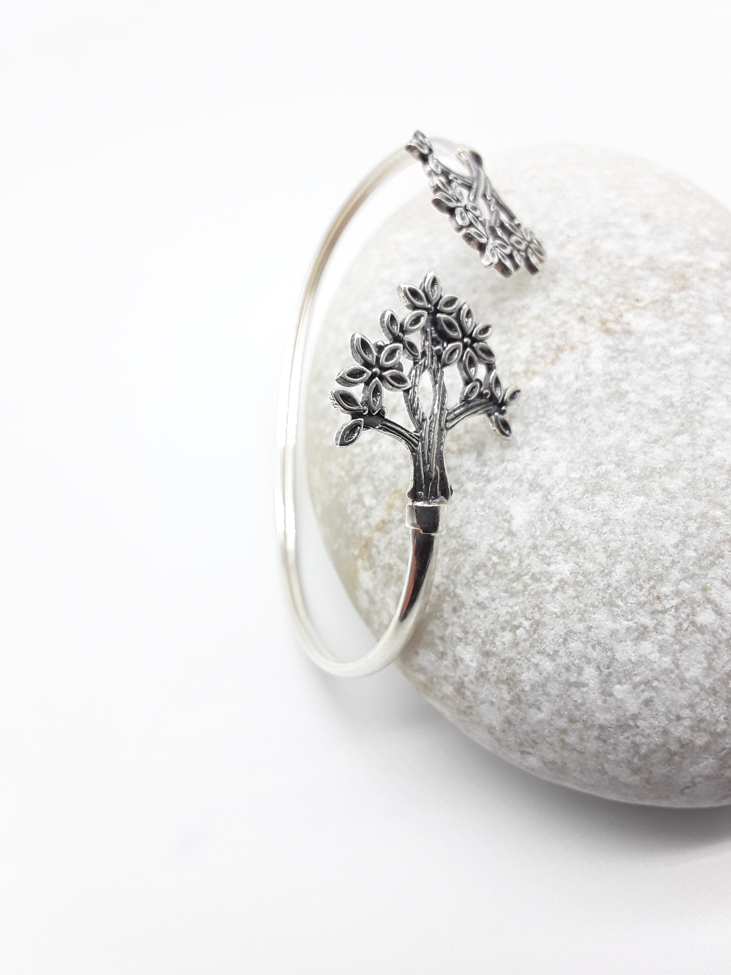 Tree of Presence sterling silver cuff bracelet beside stone — Polmadeva