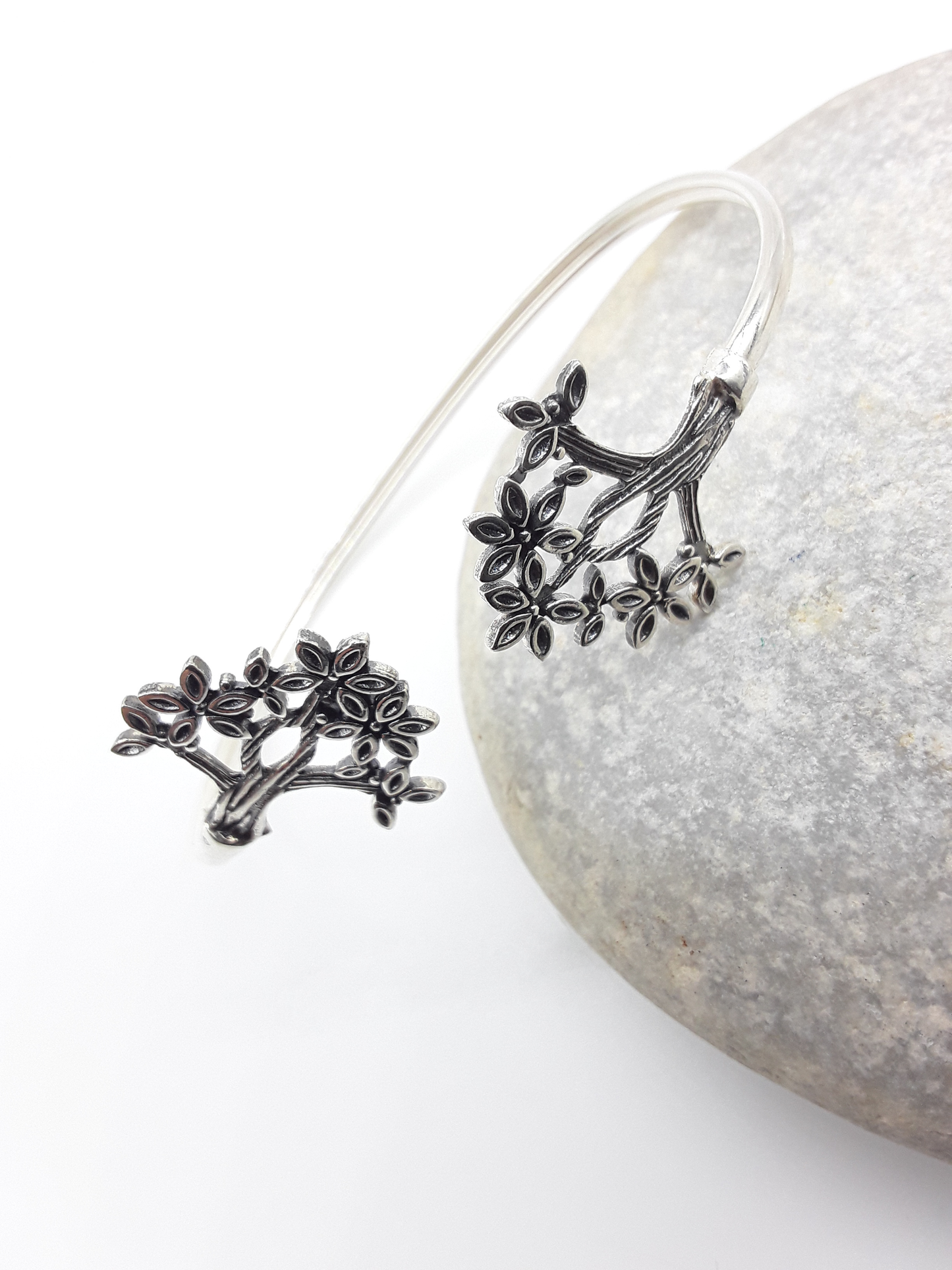 Tree of Presence sterling silver cuff bracelet beside stone — Polmadeva