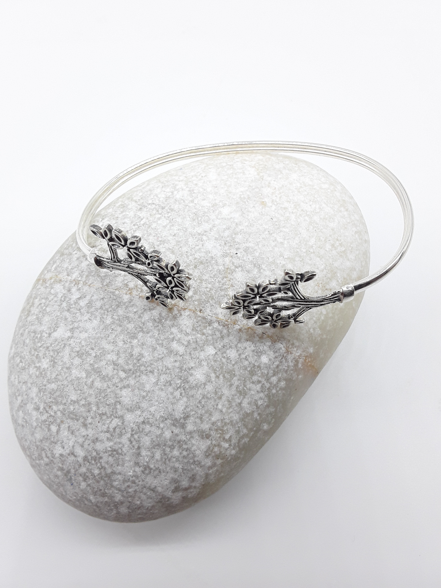 Tree of Presence sterling silver cuff bracelet beside stone — Polmadeva
