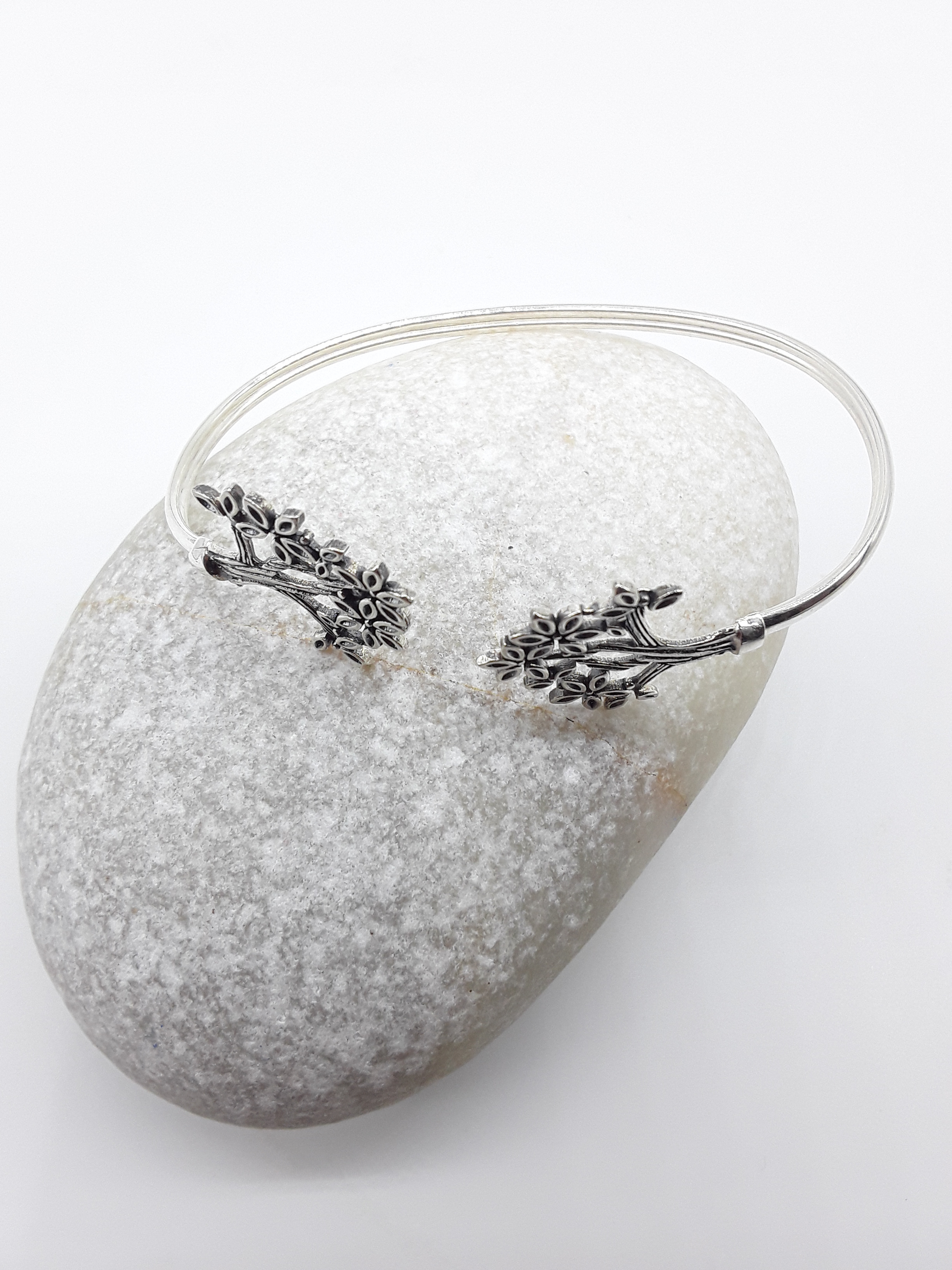 Tree of Presence sterling silver cuff bracelet beside stone — Polmadeva