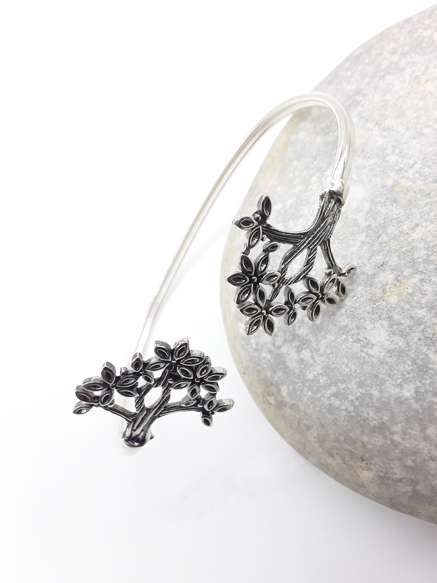 Tree of Presence sterling silver cuff bracelet beside stone — Polmadeva